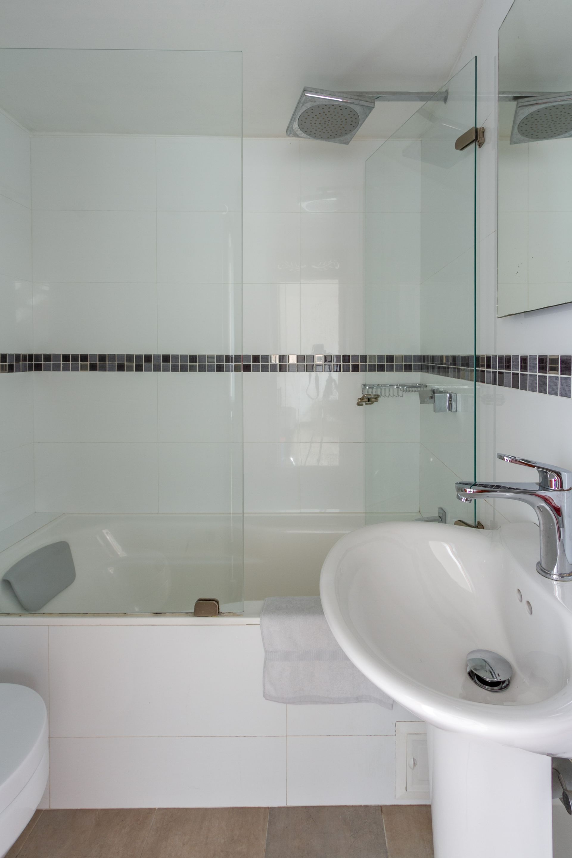 A bathroom with a sink , toilet and shower.