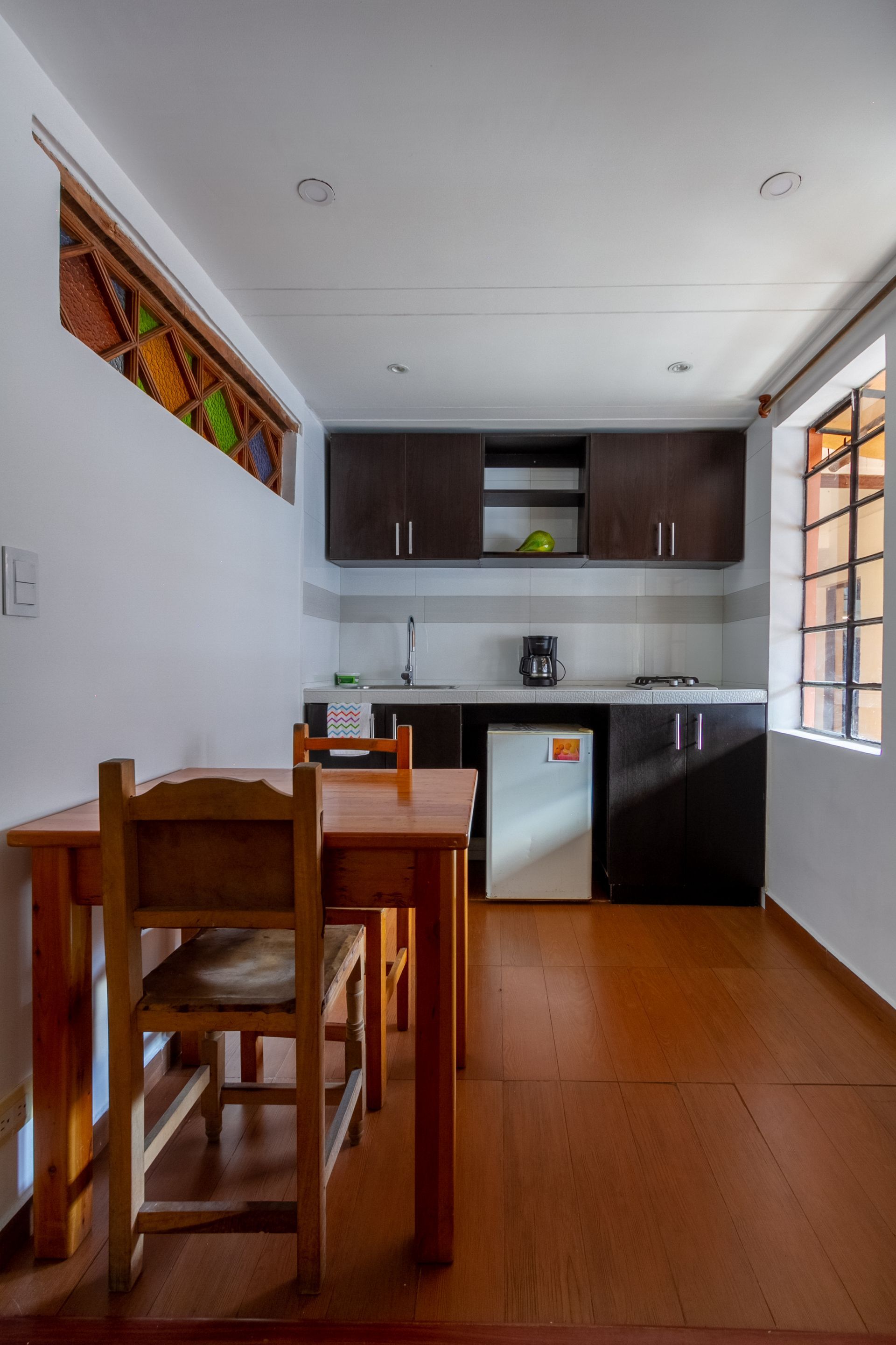 A kitchen with a table and chairs and a refrigerator