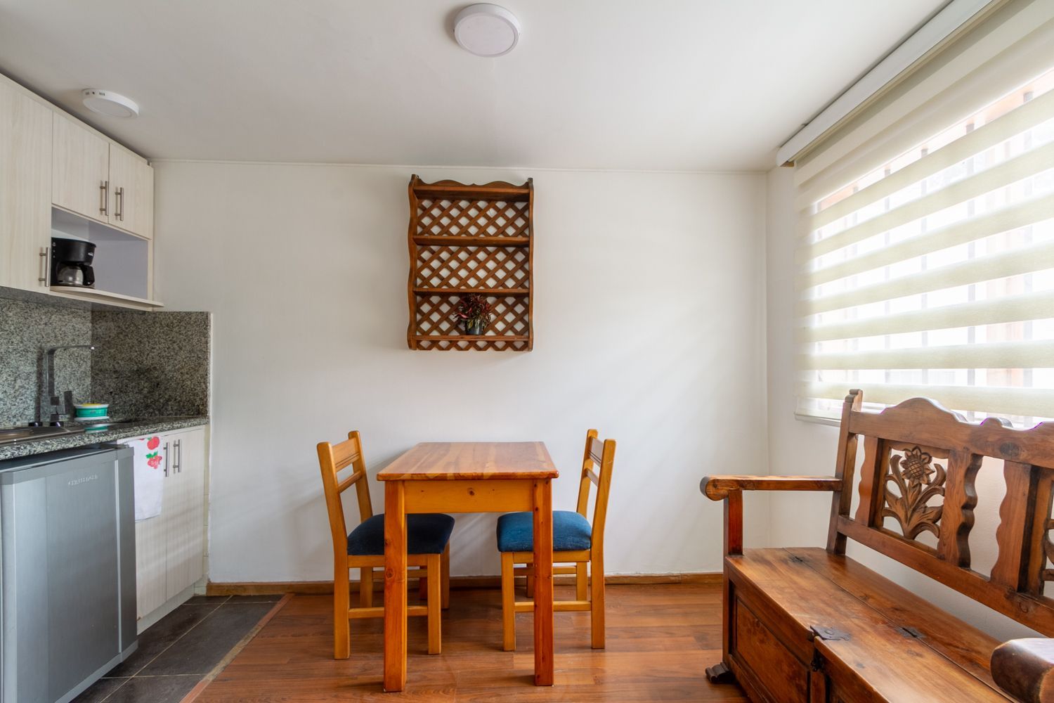 A kitchen with a table and chairs and a bench.
