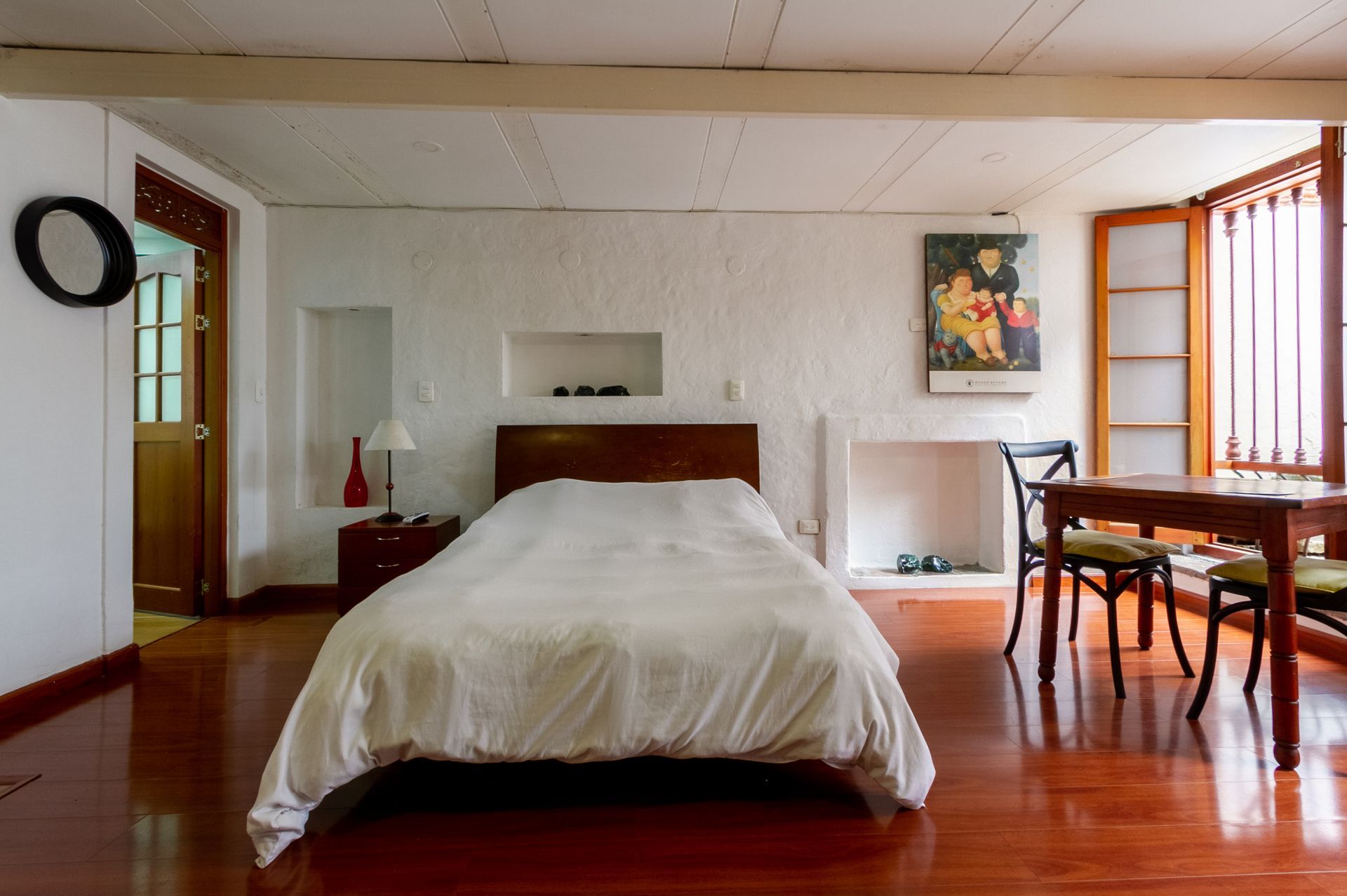 A bedroom with a bed and a table and chairs