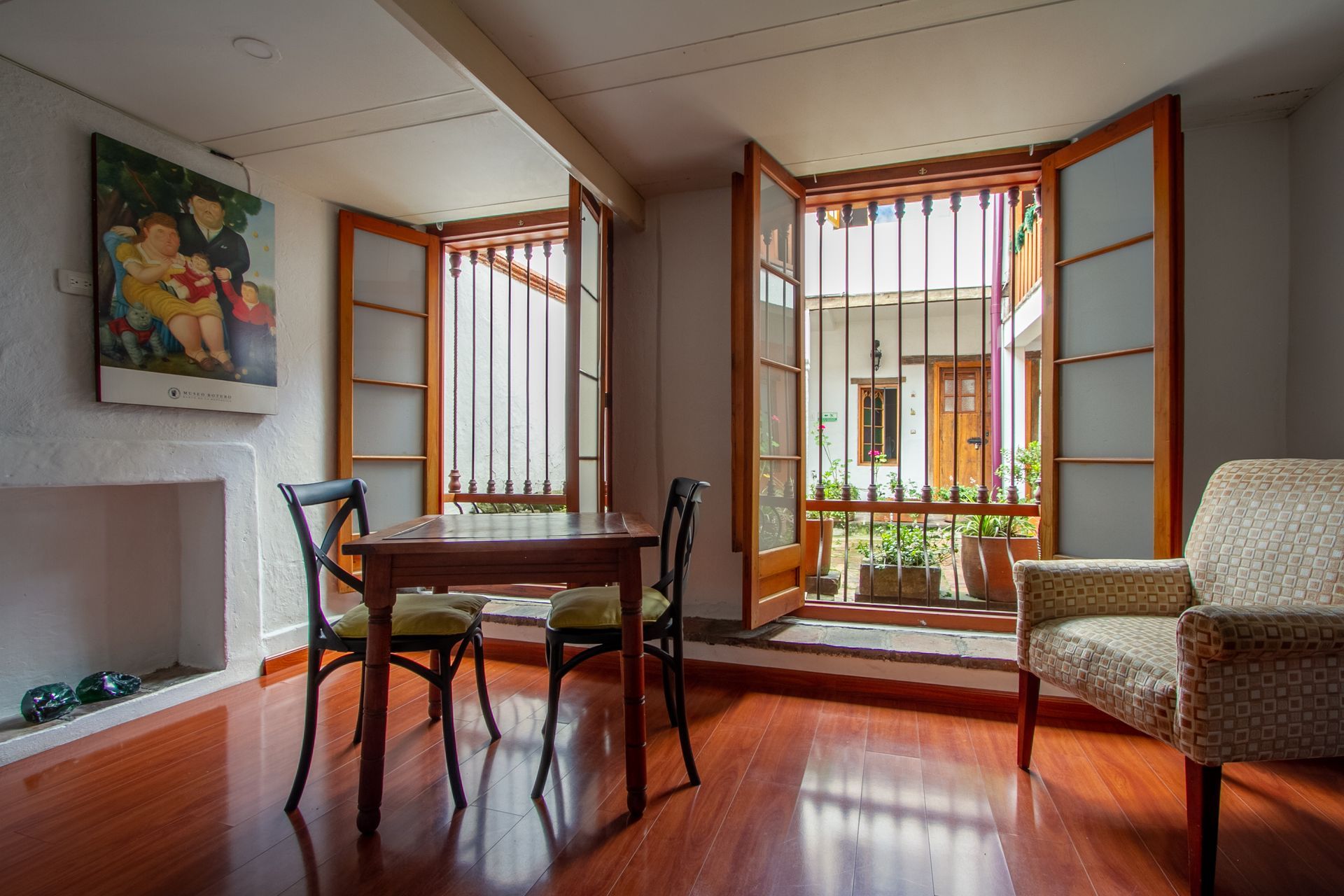 A living room with a table and chairs and a painting on the wall