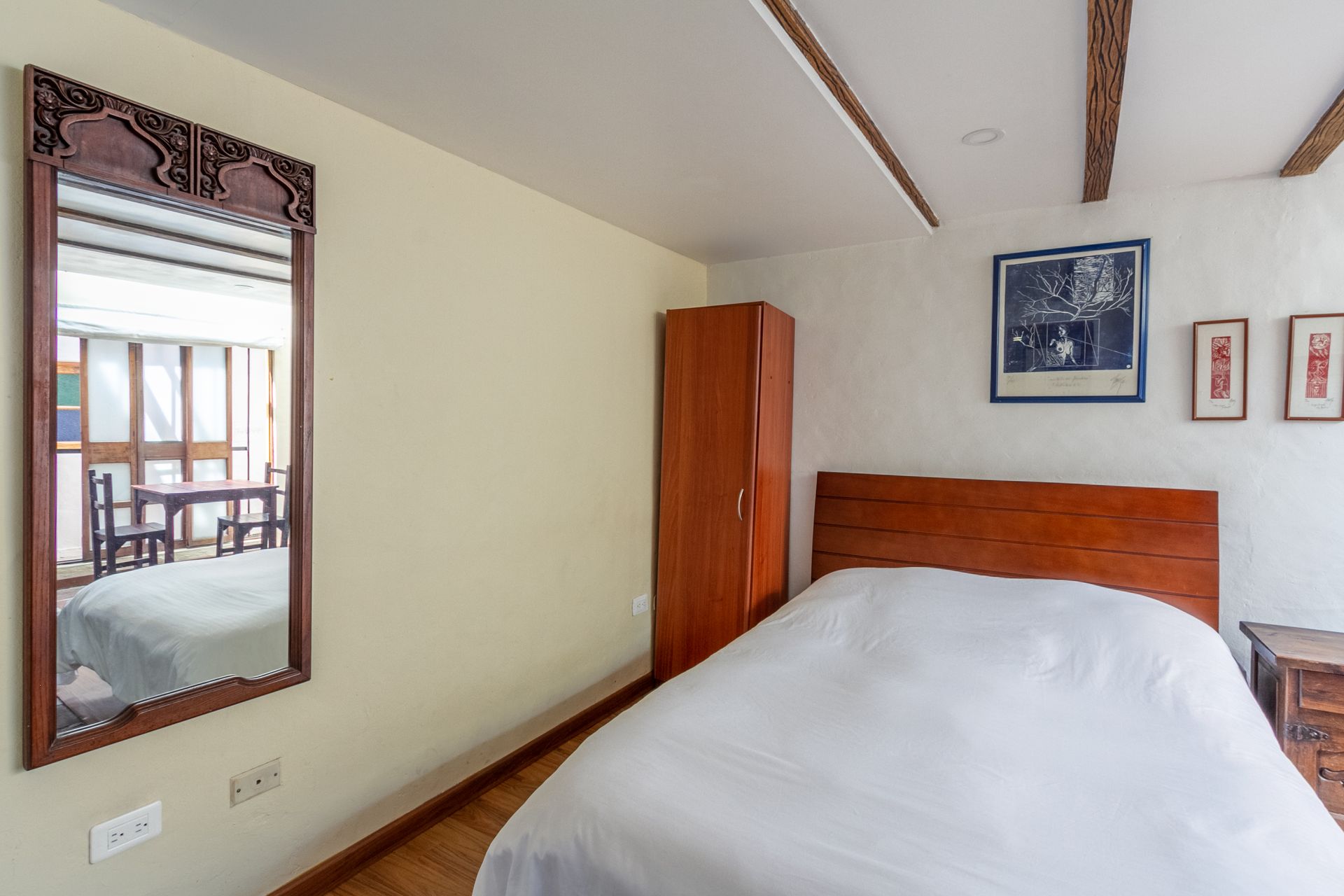 A bedroom with a bed and a mirror on the wall