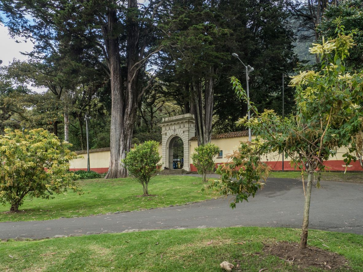 A park with trees and a stone archway in the middle of it