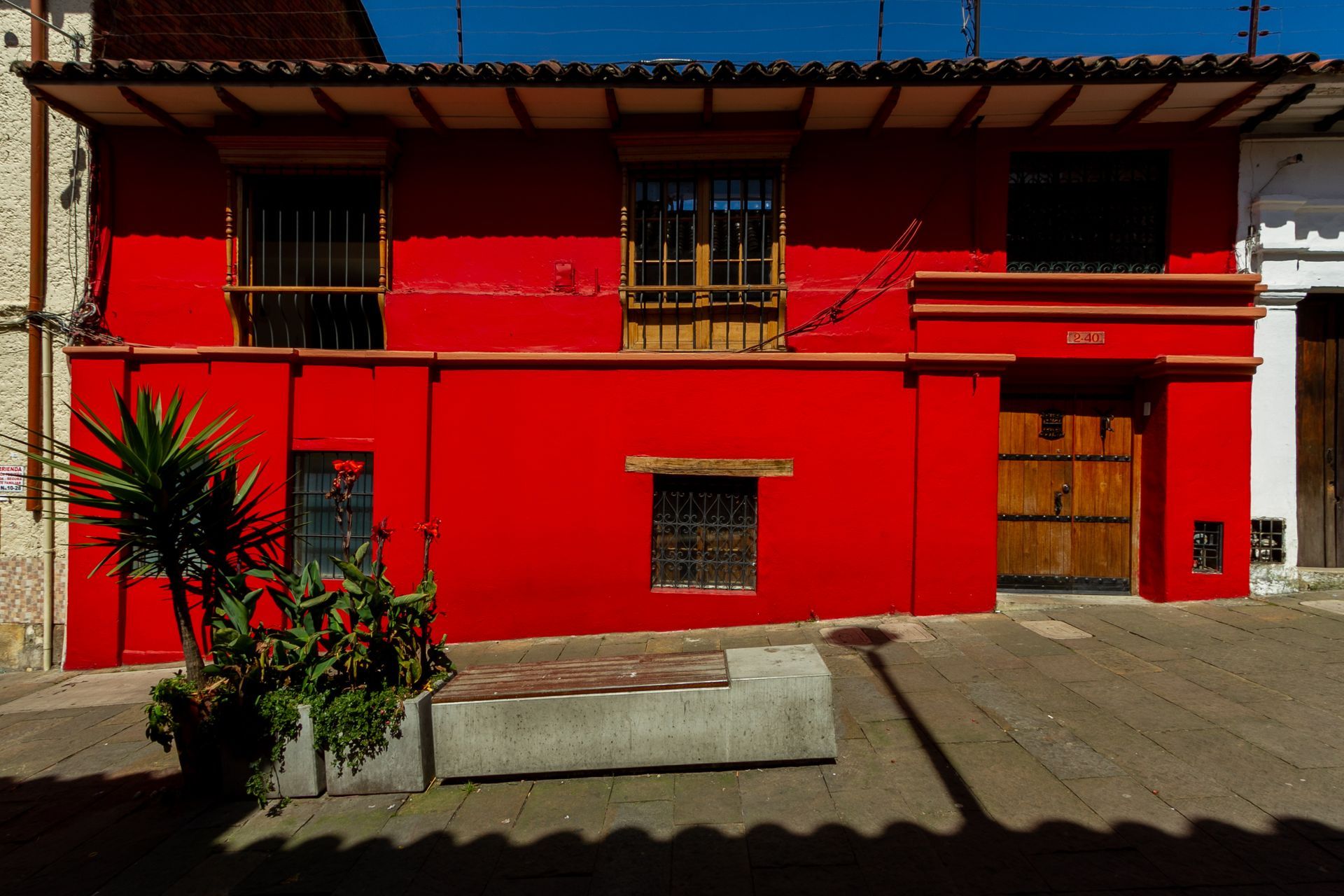 A red building with a bench in front of it