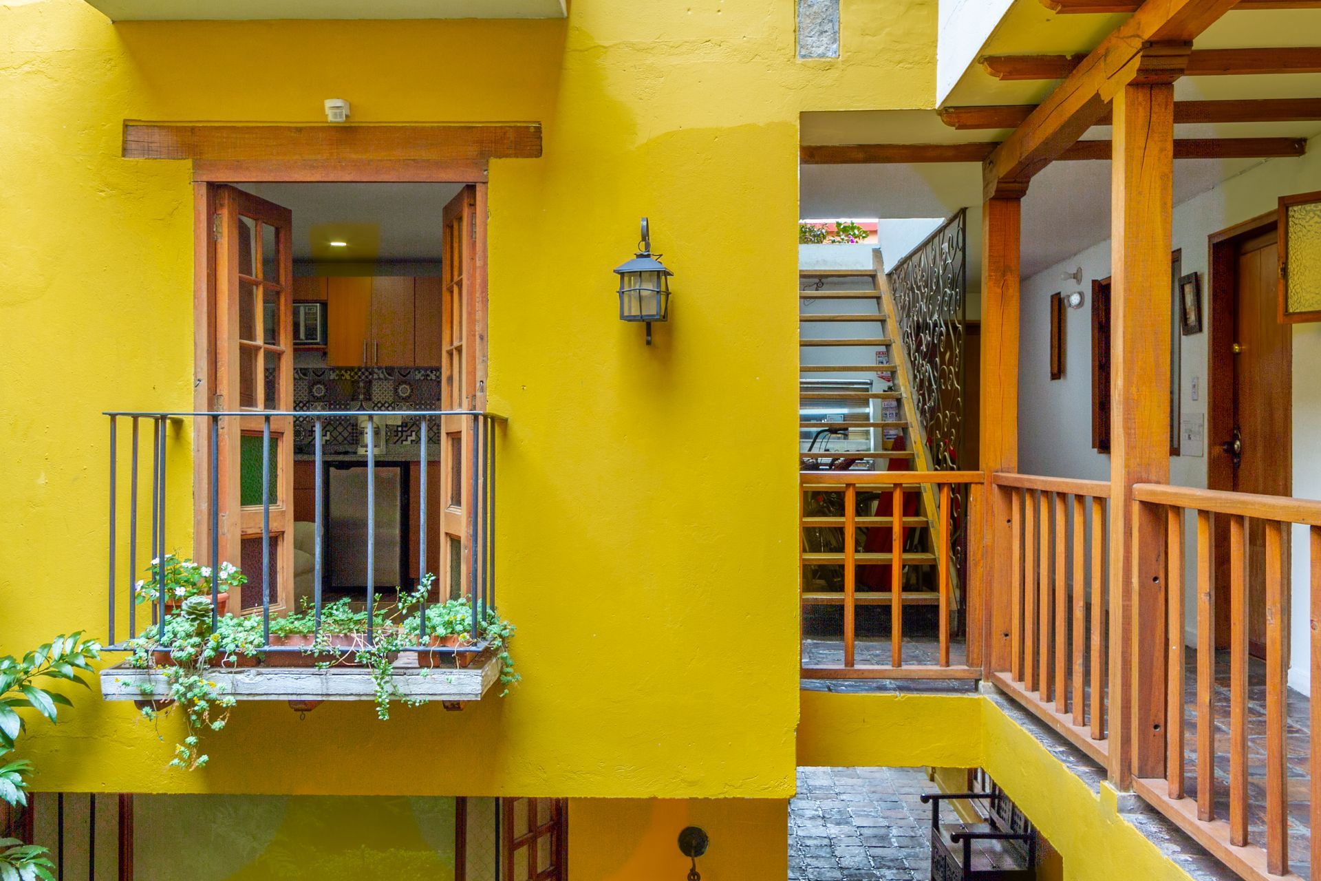 A yellow building with a balcony and stairs