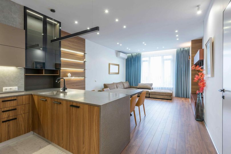 A kitchen with wooden cabinets and a large island in the middle of the room.