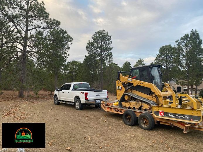 A white truck is towing a bulldozer on a trailer.
