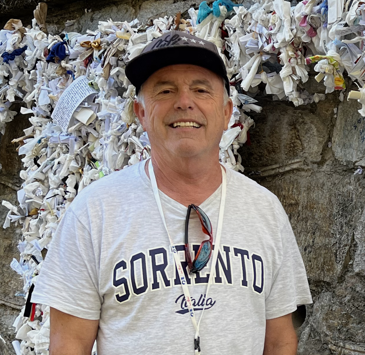 A man wearing a sorrento t-shirt is standing in front of a wall