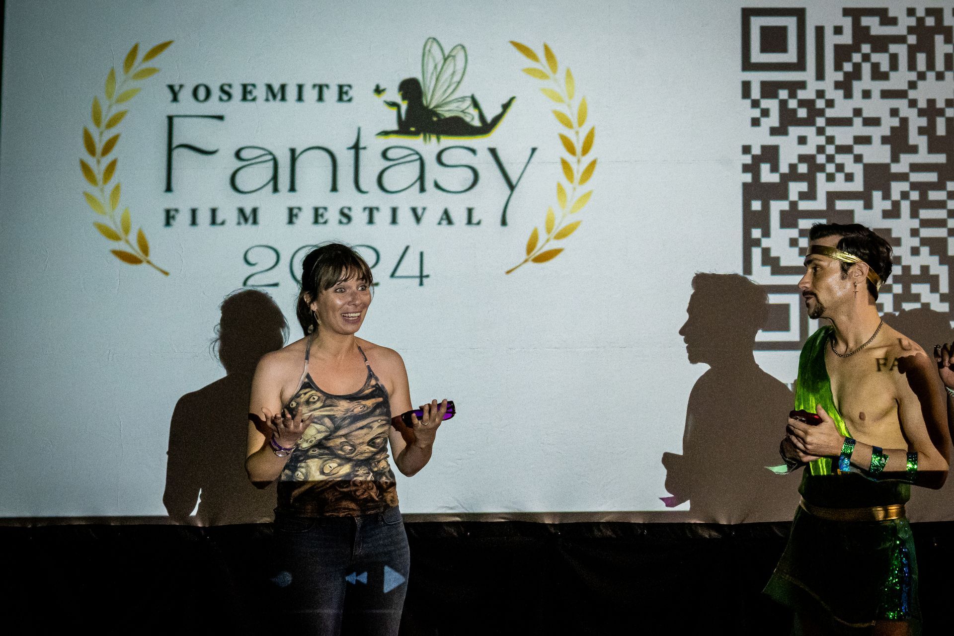 A woman stands in front of a yosemite fantasy film festival sign