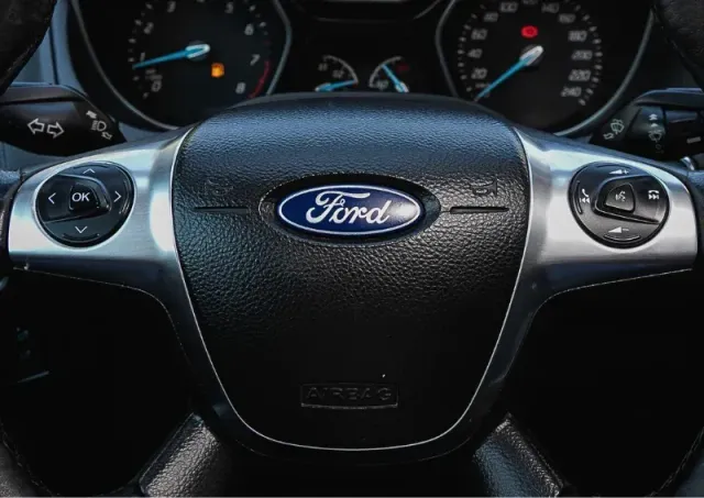 Ford steering wheel with dashboard gauges in the background