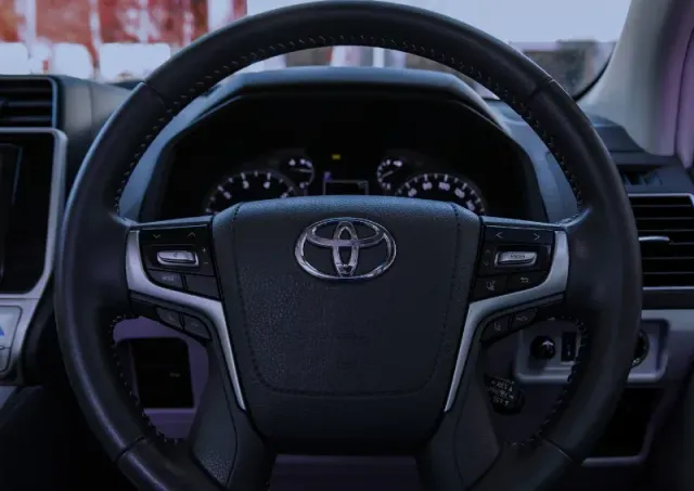 Toyota steering wheel and dashboard view inside a car interior