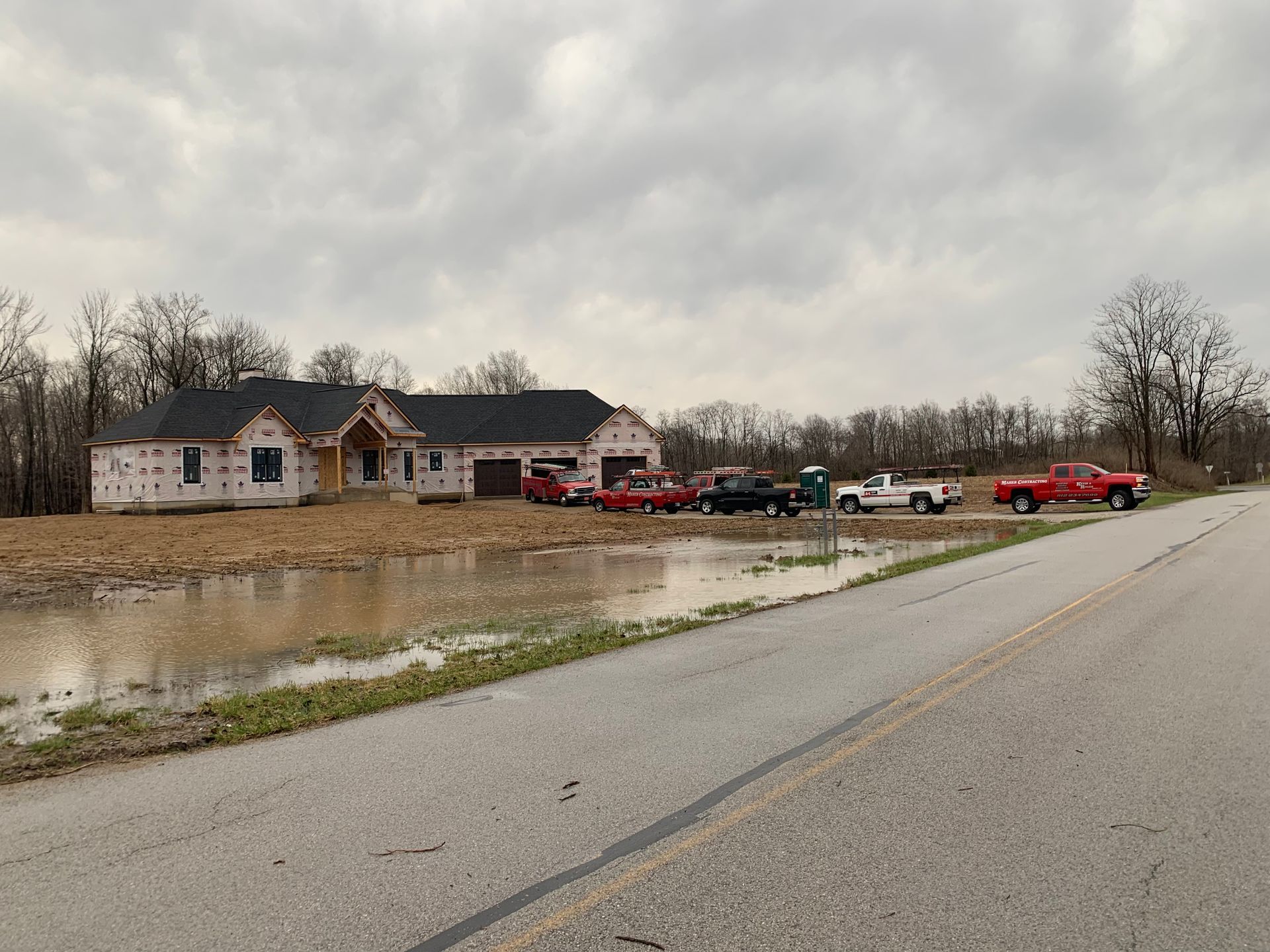 Blue siding house with white trim, three windows on lower level, one triangular window above.