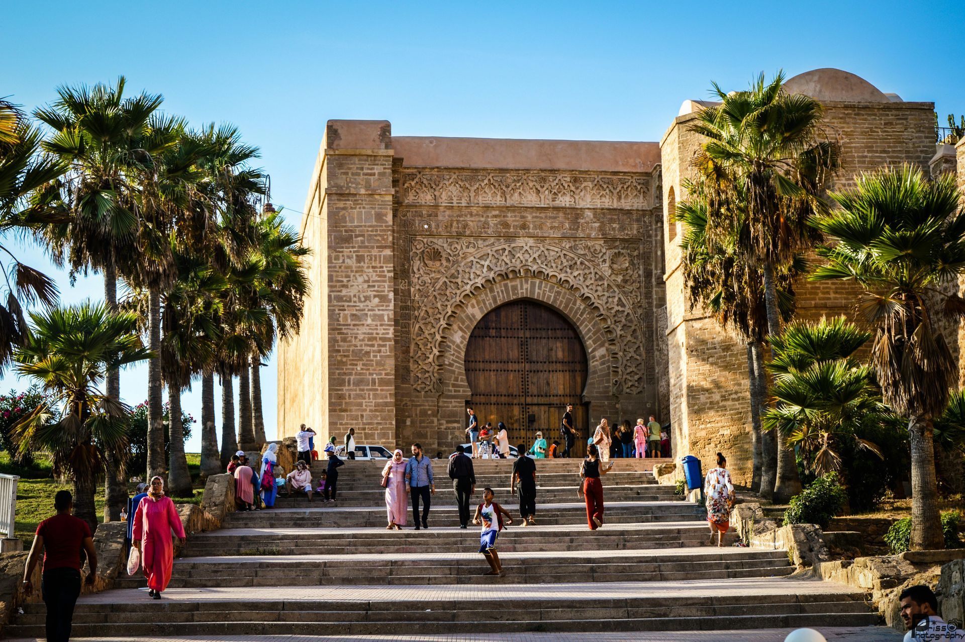 A group of people are walking down stairs in front of a building.