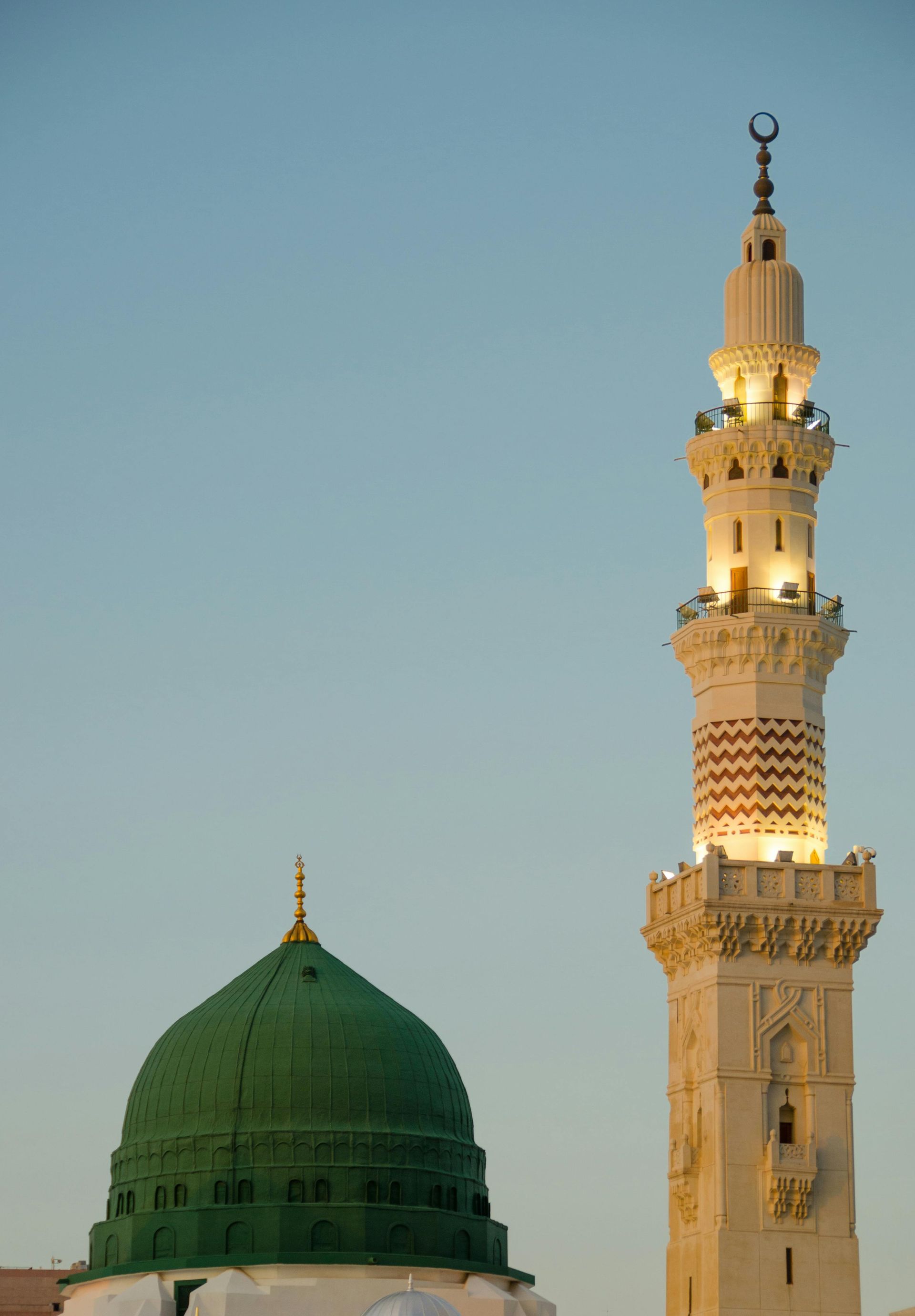 A mosque with a green dome and a white tower