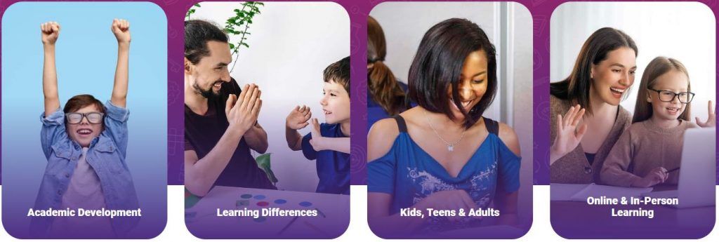 A group of people are sitting at a table with their hands in the air.