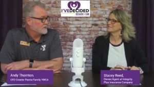 A man and a woman are sitting in front of a microphone.