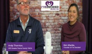 A man and a woman are sitting in front of a microphone.