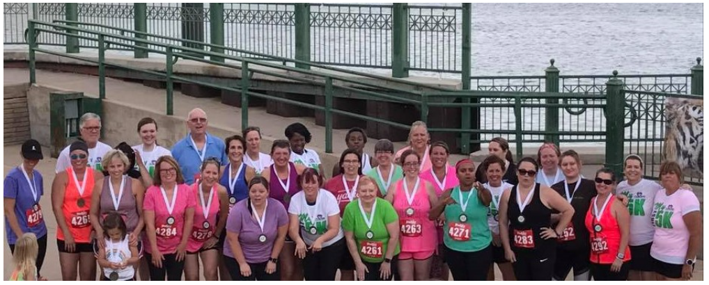 A group of people wearing medals are posing for a picture.