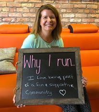 A woman is sitting on a couch holding a sign that says `` why i run ''.