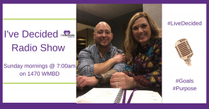 A man and a woman are sitting at a table with a sign that says i 've decided radio show