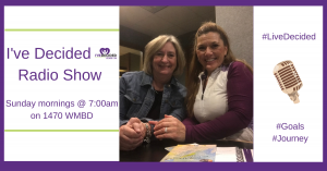 Two women are sitting at a table in front of a sign that says i 've decided radio show