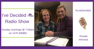 Two people are sitting at a table with a sign that says i 've decided radio show