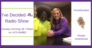 Two women are sitting at a table in front of a sign that says i 've decided radio show