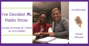 Two women are sitting at a table in front of a sign that says i 've decided radio show