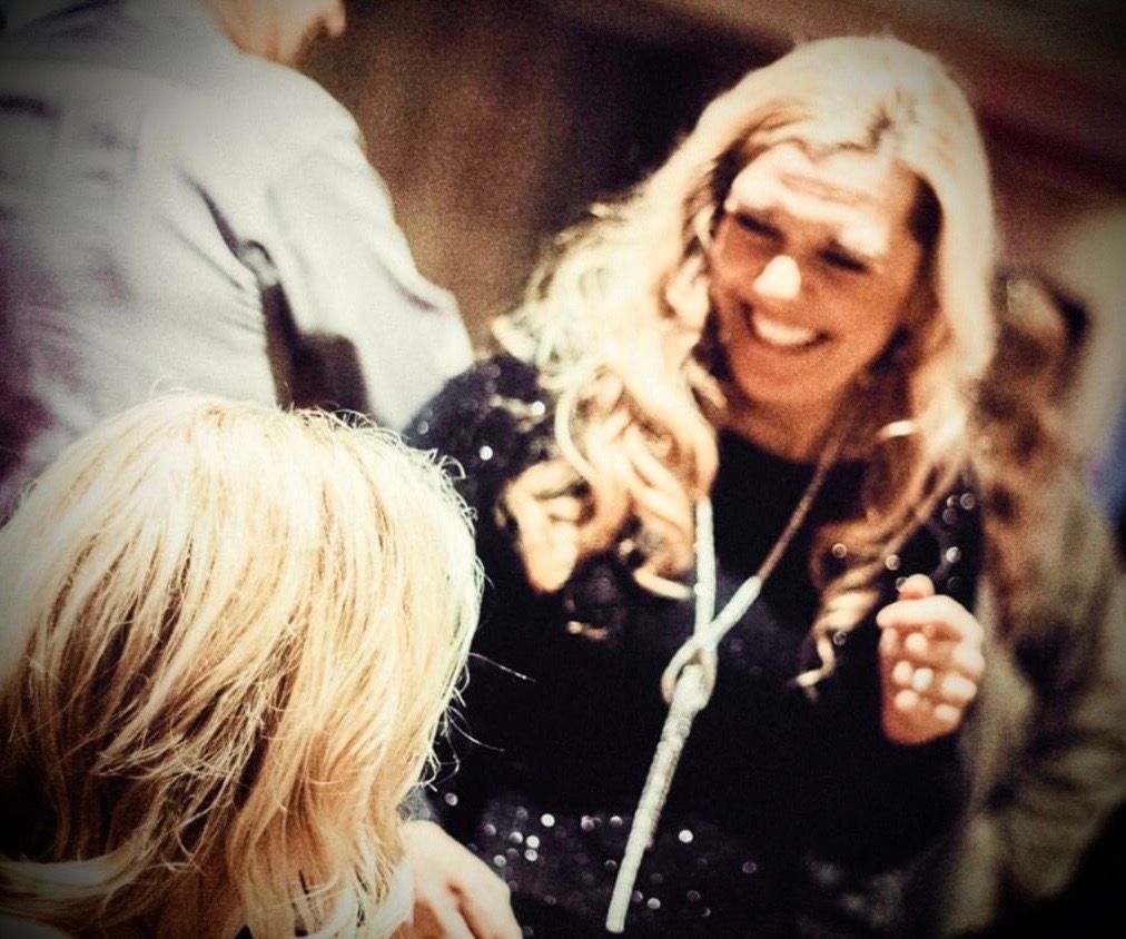 A woman is smiling while talking to another woman