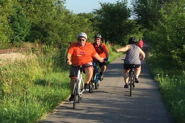 A group of people are riding bicycles down a path.