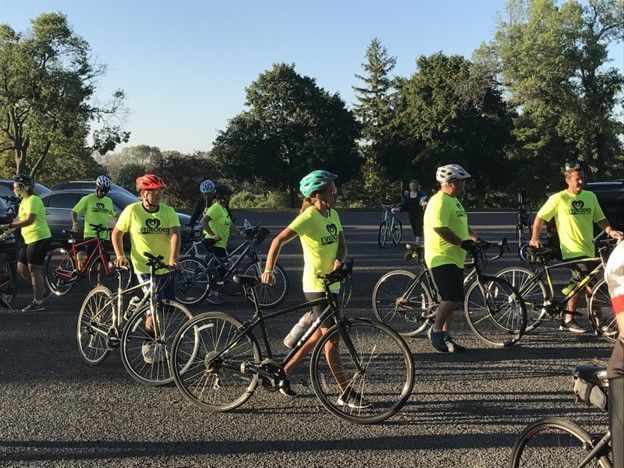 A group of people wearing neon green shirts are riding bicycles