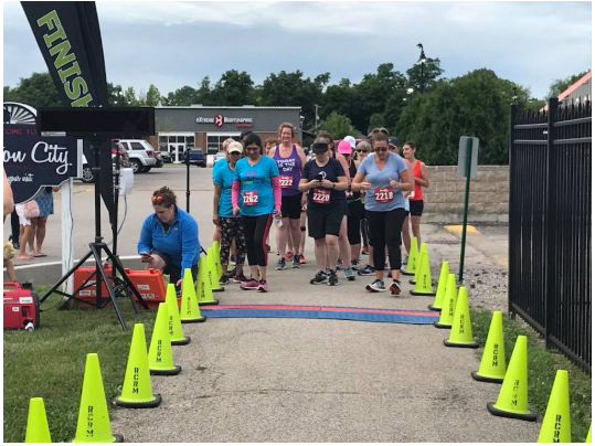 A group of people are walking towards a finish line