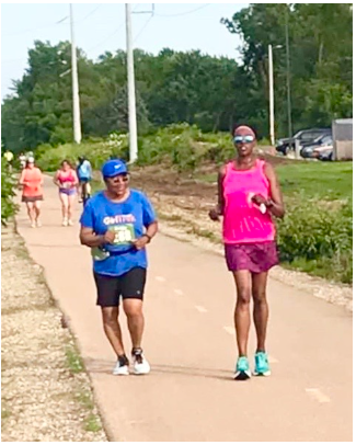 A man and a woman are walking down a path.