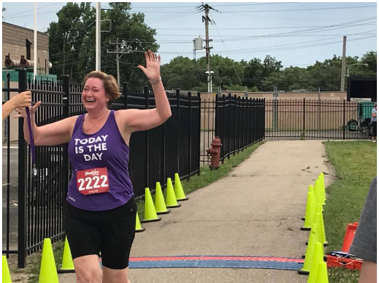 A woman wearing a purple tank top that says today is the day