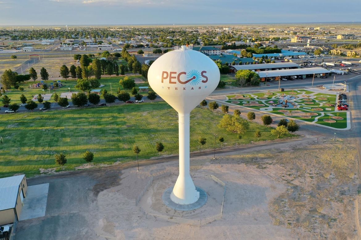 An aerial view of a water tower that says pecs on it