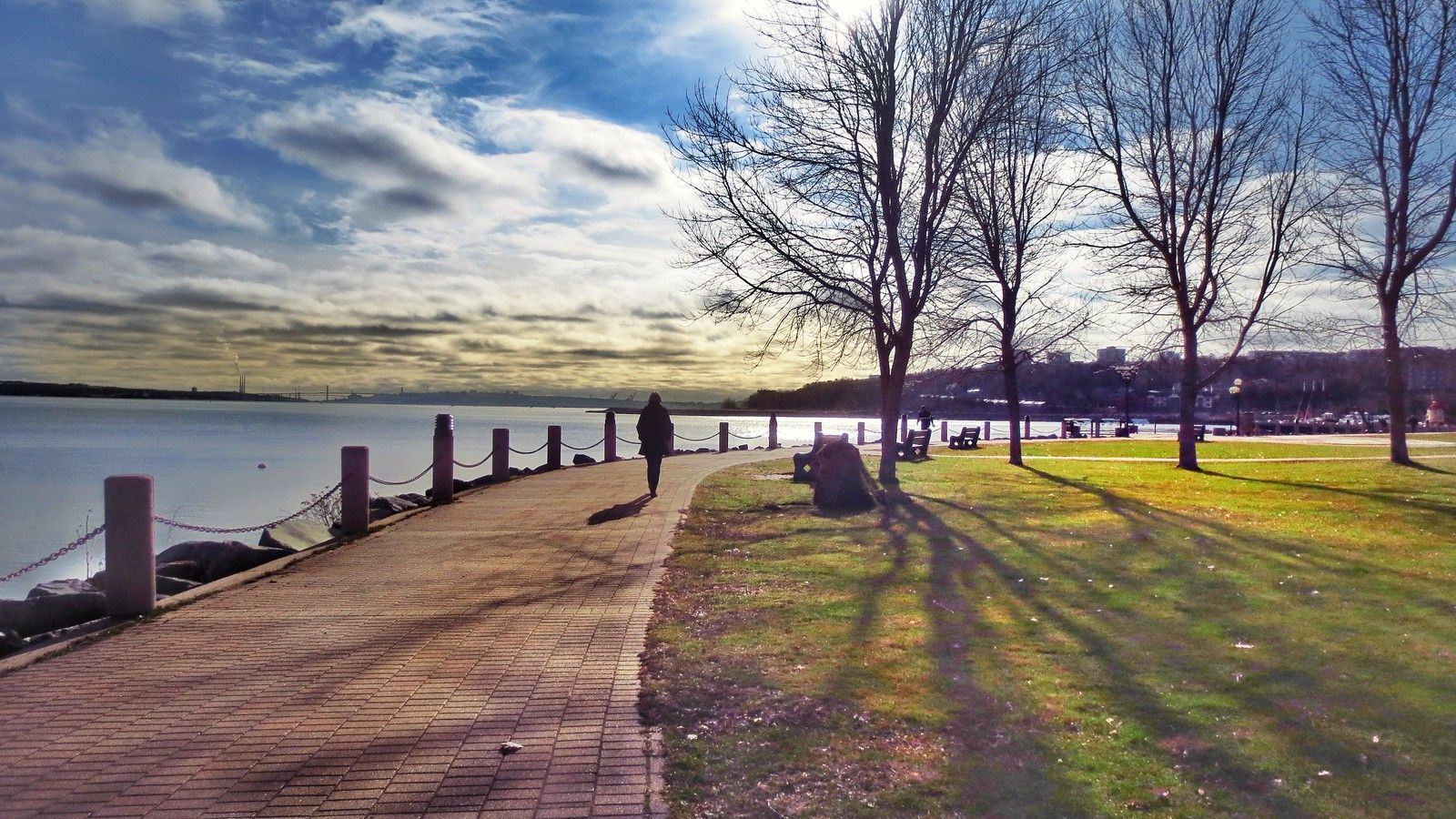 A person is walking along a path next to a body of water