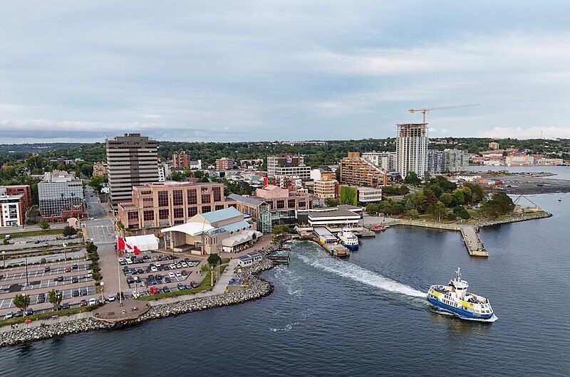 An aerial view of a city with a boat in the water.