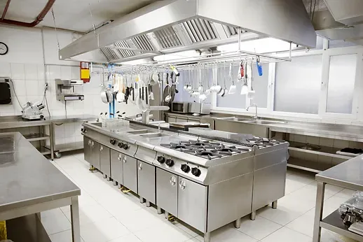 A large commercial kitchen with a lot of stainless steel appliances.