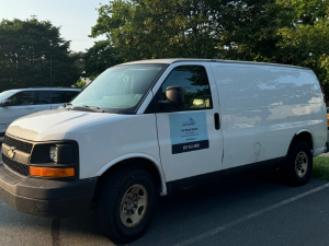 A white van is parked on the side of the road