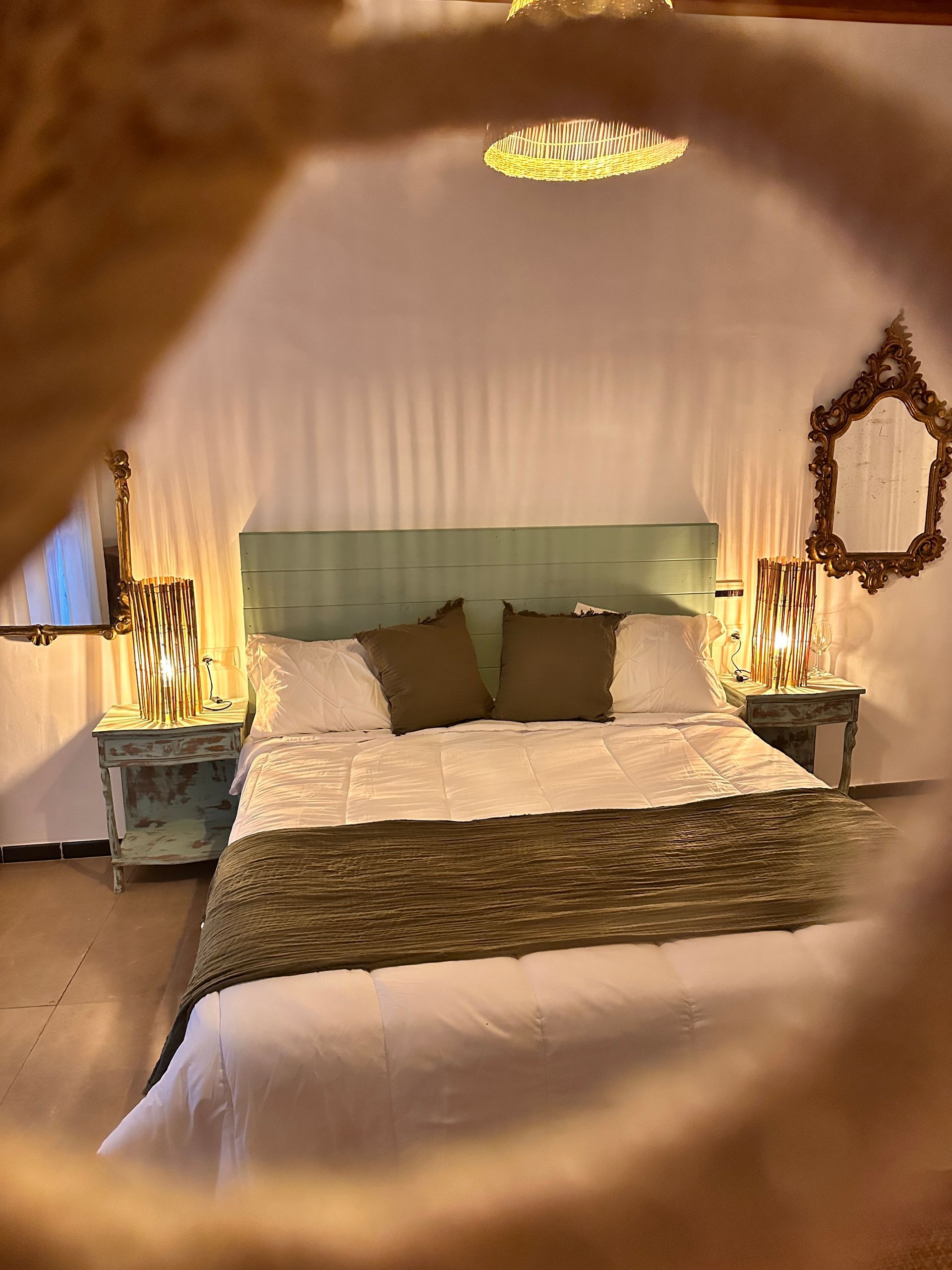 Un dormitorio con una cama, mesitas de noche y un espejo.