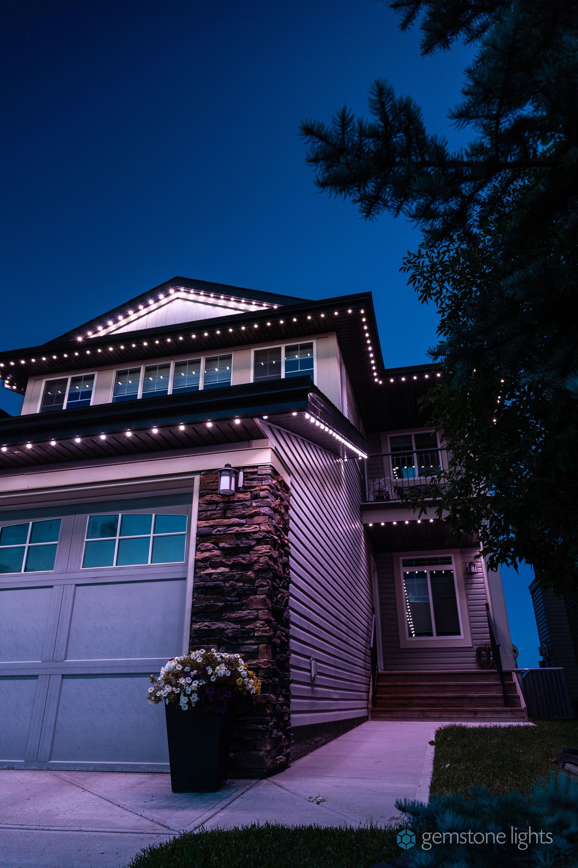 A house is lit up with christmas lights at night