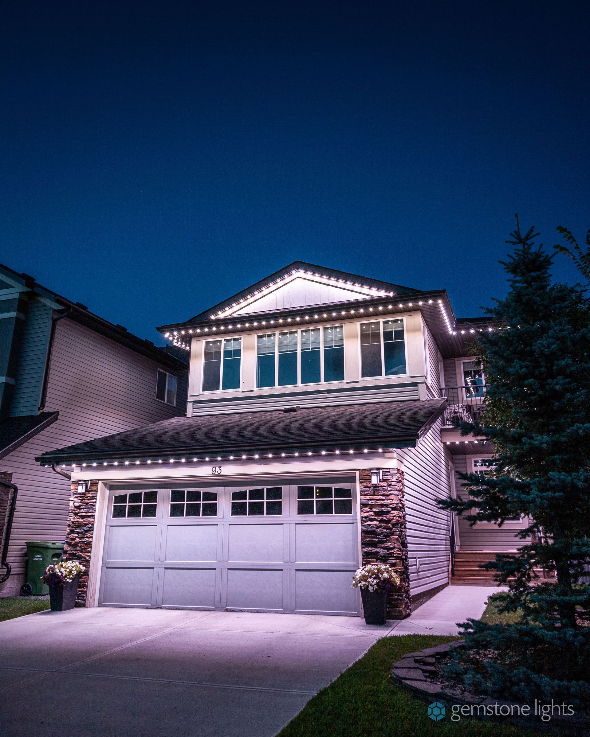 A house with christmas lights on it is lit up at night