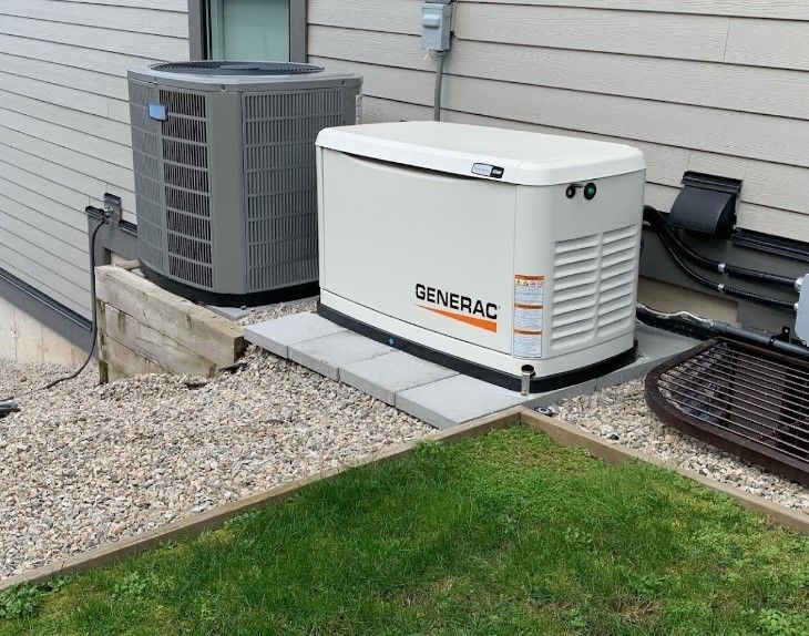 A Generac generator and an HVAC condenser unit sit on a gravel ground cover next to the exterior siding of a house.