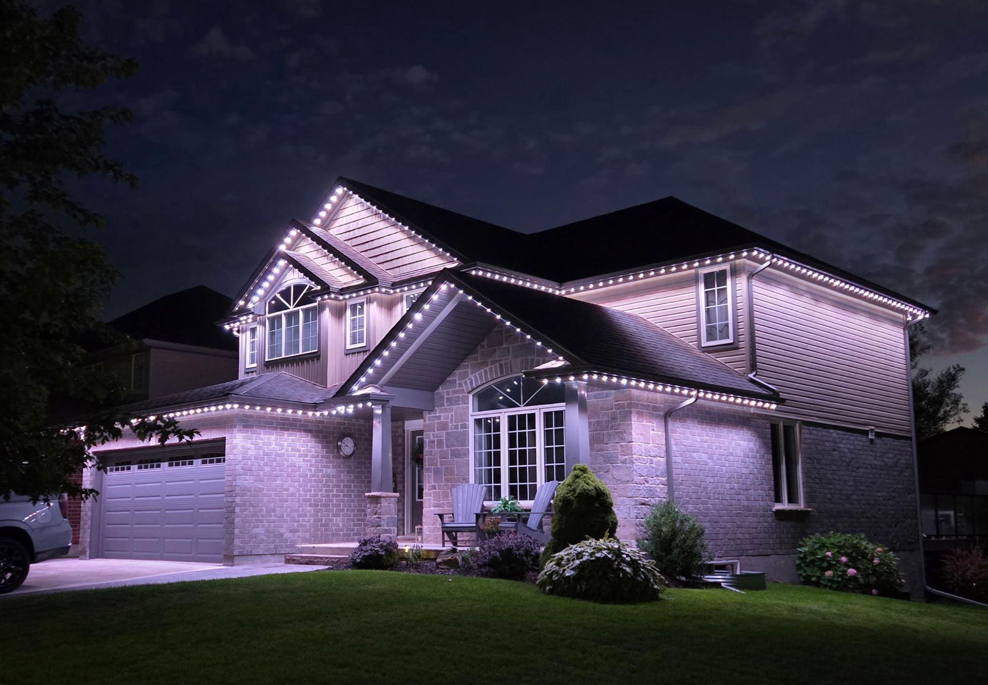 House decorated with white Christmas lights at dusk.
