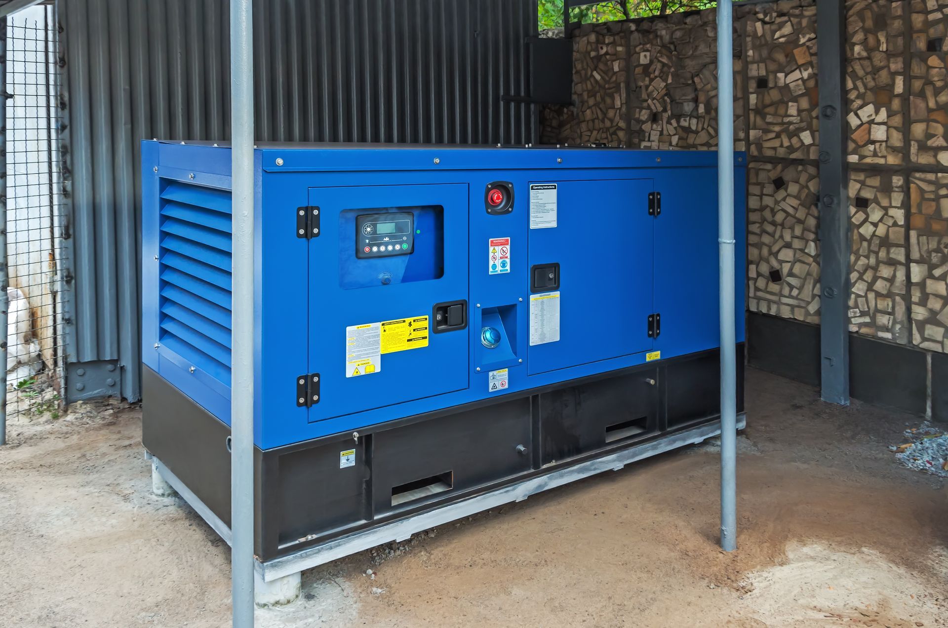 A blue and black generator is sitting under a metal structure.