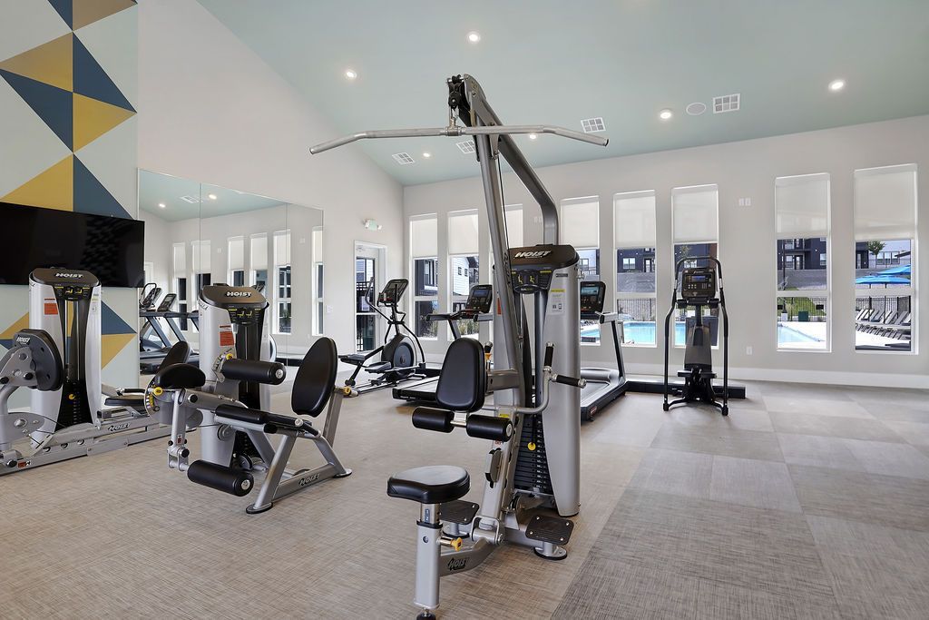 Bright modern fitness center with cardio machines and weight machines.