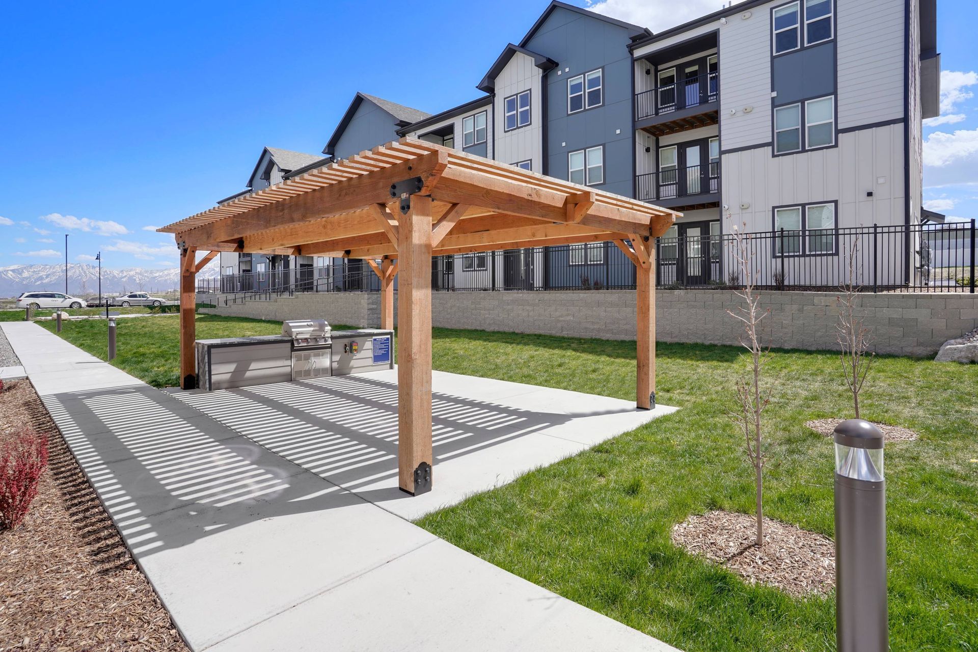 Wood pergola over a grill station in an apartment community courtyard.