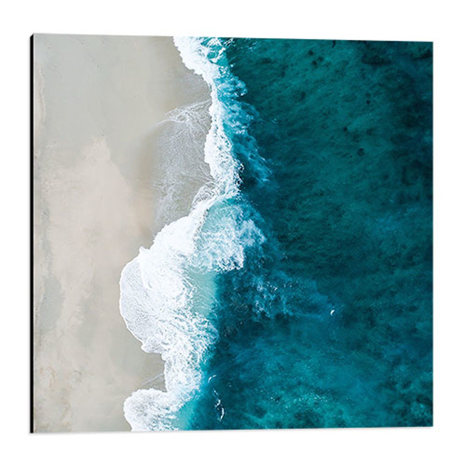 Aerial view of turquoise waves breaking onto a white sandy beach