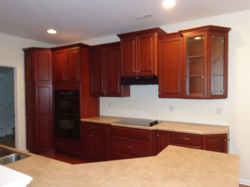 Dark wood kitchen cabinets with light countertop and built-in appliances.