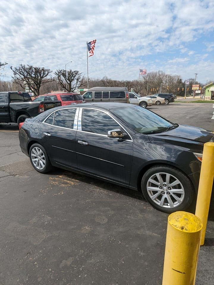 Exterior of "Radio Knob" building with a few cars parked in front.